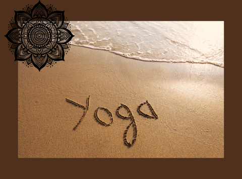 The word yoga written in sand on a beach