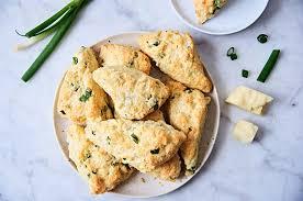 Pictured is a plate of herb scones, with butter and herbs on the side. 
